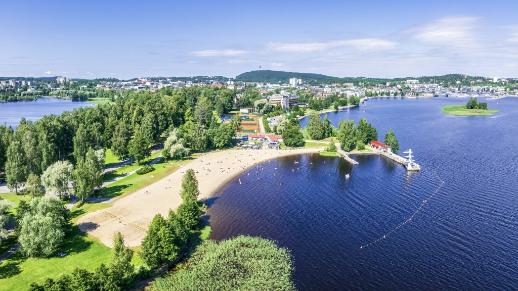 Ilmakuva kesäisestä uimarannasta aurinkoisena päivänä.