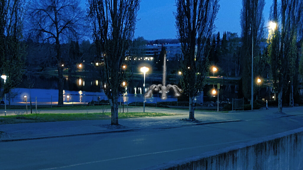 Pimeässä lammen rannalla näkyviä puita sekä havainnekuva suihkulähteestä, taustalla kerrostaloja.