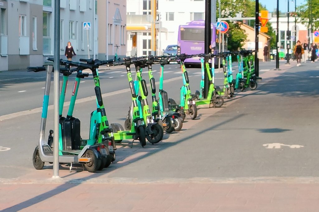 Sähköpotkulautoja pysäköitynä Tulliportinkadun pyörätien ja jalkakäytävän väliselle erottelukaistalle.