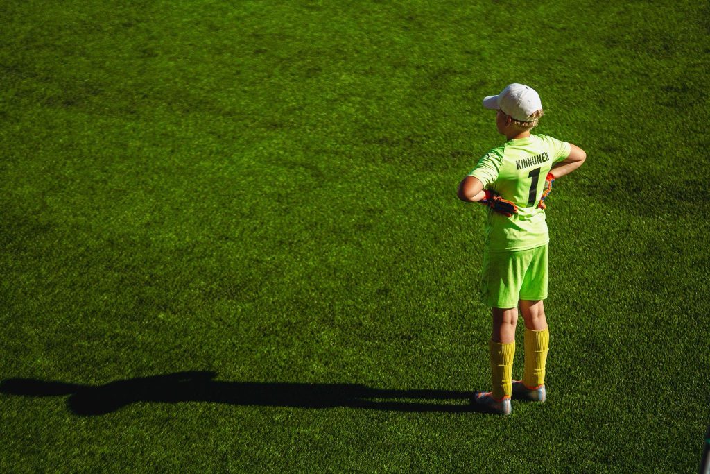 Lapsi vihreällä jalkapallokentällä