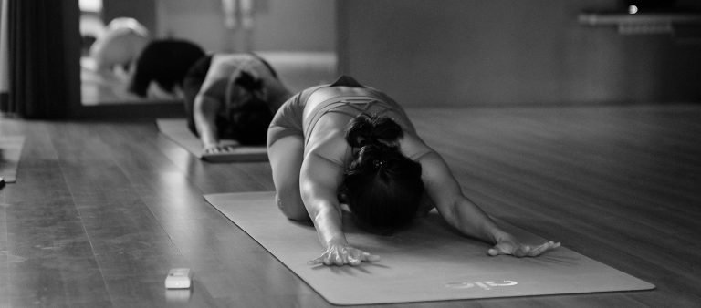 Nainen pilateksen venyttelyasennossa.