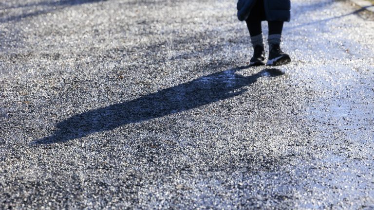 Hiekoitettu katu, jossa kävelee yksi tummissa vaatteissa oleva henkilö.