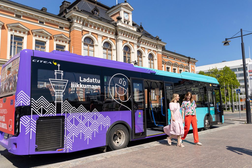 Kaksi henkilöä nousee sähköbussista.