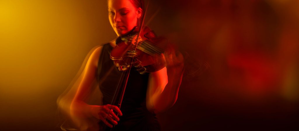 Orkesterin alttoviulisti utuisella, ruskeasävyisellä taustalla.