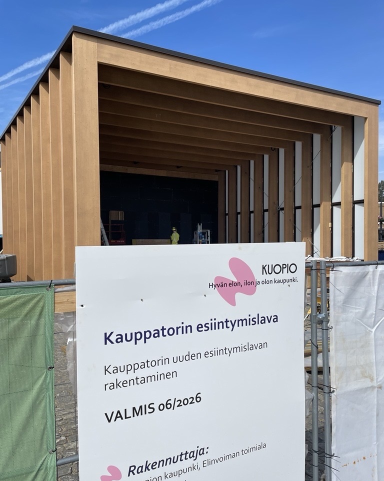 Kuvassa on kauppatorille valmistuva puunvärinen torilava. Etualalla on kyltti, jossa ilmoitetaan rakennuttaja- ja valmistumistiedot.