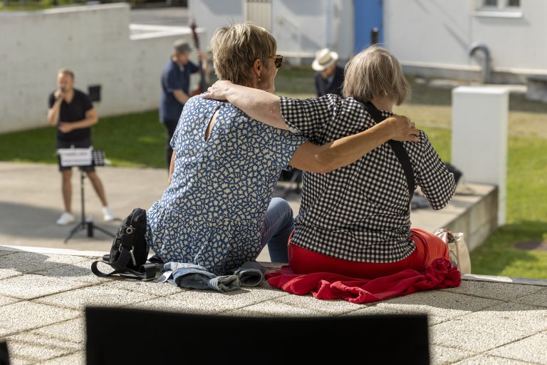 kaksi naista istuu ja katselee orkesteria
