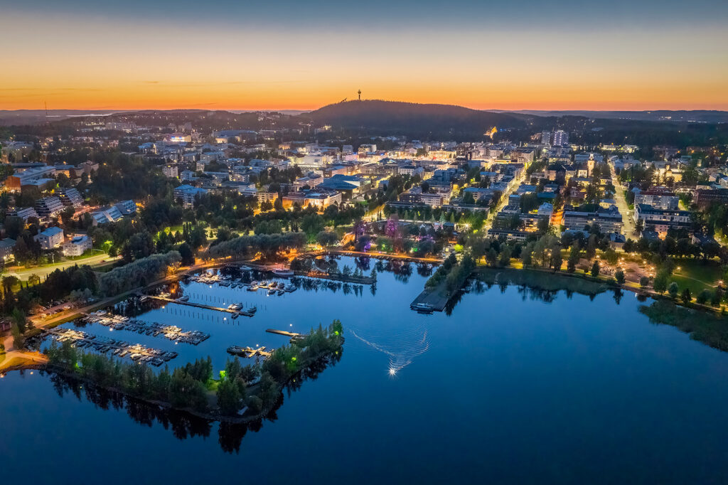 Kuopion kaupunkimaisema ilta-auringossa. Etualalla kallavesi ja taustalla Puijon torni.