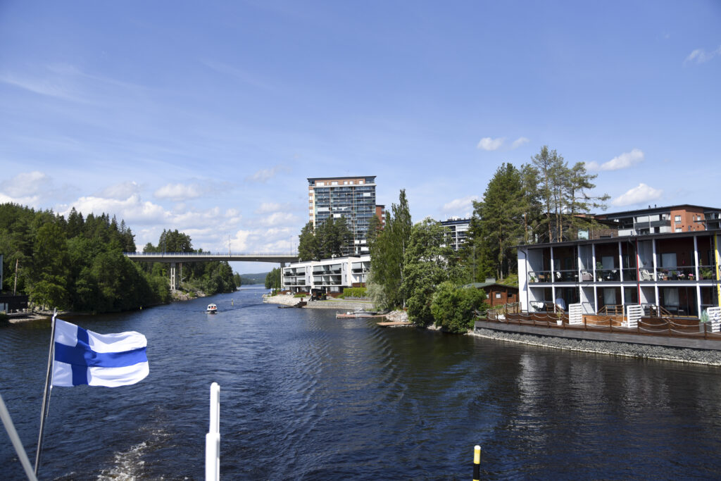 Näkymä laivan takakannelta Keilankannan kanavaan, jonka rannalla näkyy rivi- ja kerrostataloja.