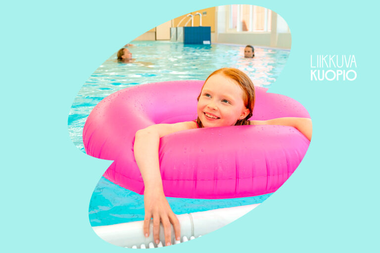 Punahiuksinen tyttö uimassa pinkillä uimarenkaalla uimahallissa.
