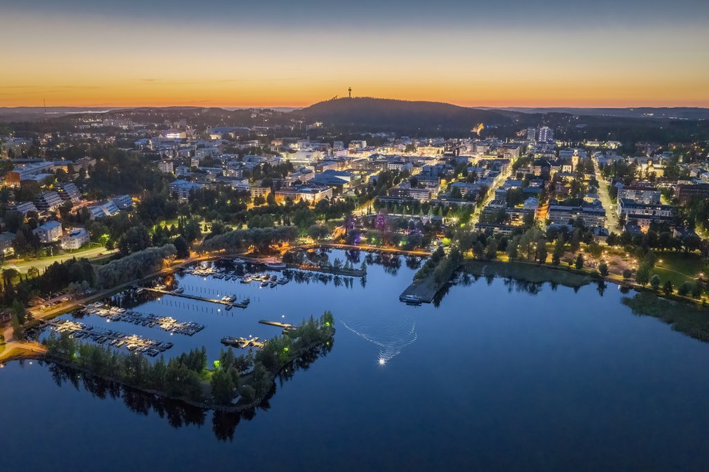 Öinen näkymä Kuopion satama-alueesta. Järvi ja valaistua kaupungin ruutukaavaa.