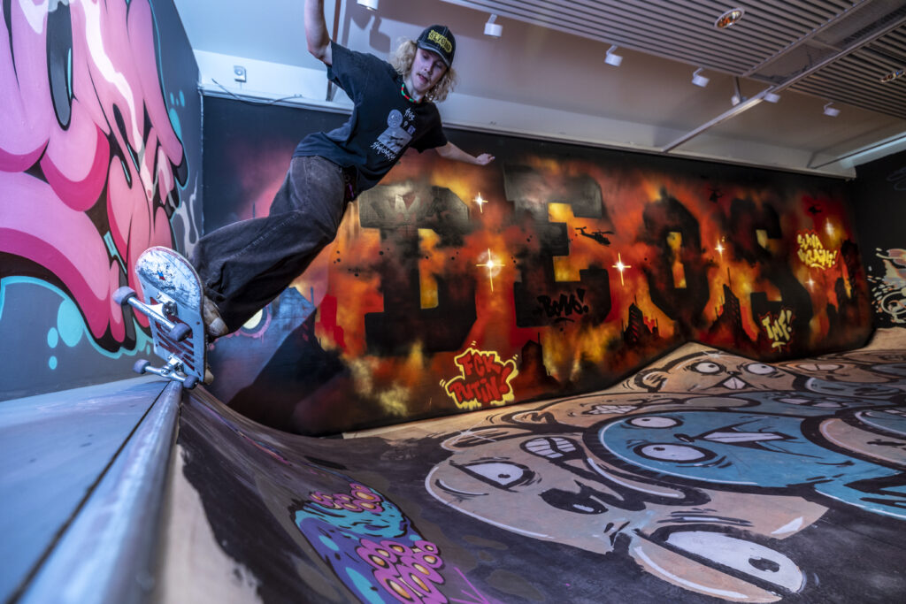 Kannun henki -näyttelystä Kuopion taidemuseolta kuva, jossa henkilö skeittaa ja taustalla graffiteja