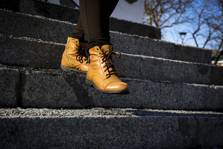 Henkilö kävelee portaita alas keltaisissa kengissä