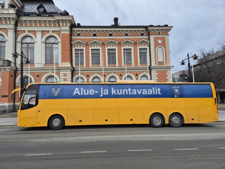Keltainen äänestysbussi kaupungintalon edustalla Kuopiossa.