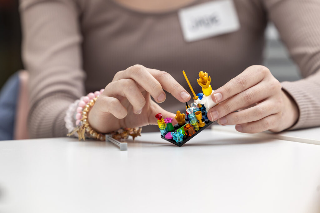Nuoren kädet, jotka rakentavat legoja.